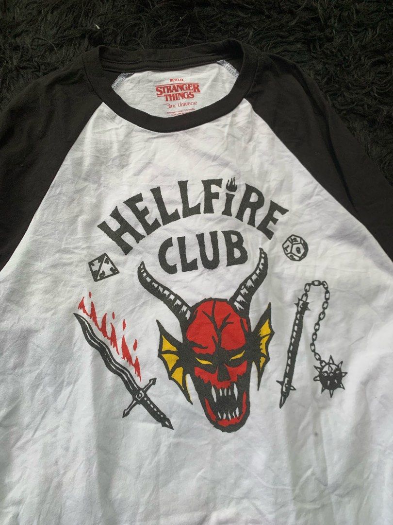 Stranger Things Hellfire Club Raglan T-shirt (Category: Tshirts & Polo Shirts ) located in Manila. Submitted by 0thrift_n_isaw (Listing ID 1450500297, Image 2). Description: - Stranger Things Hellfire Club Raglan Tee - Classic black sleeves and white body - Features a cool graphic print on the front - Comfortable fit, perfect for everyday wear - Ideal for fans of the hit show.