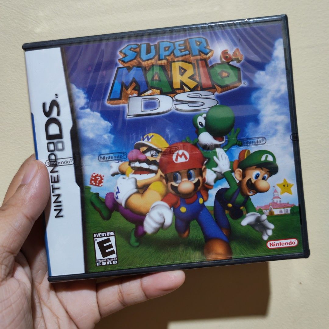 Super Mario 64 DS Nintendo DS Game (Category: Nintendo) located in Manila. Submitted by royaltree.06a603 (Listing ID 1450362297, Image 1). Description: - Super Mario 64 DS for Nintendo DS - Play as Mario, Luigi, Yoshi, and Wario - Classic platforming adventure - Explore diverse worlds and collect stars - Perfect for any Mario fan - Includes game cartridge and original case.