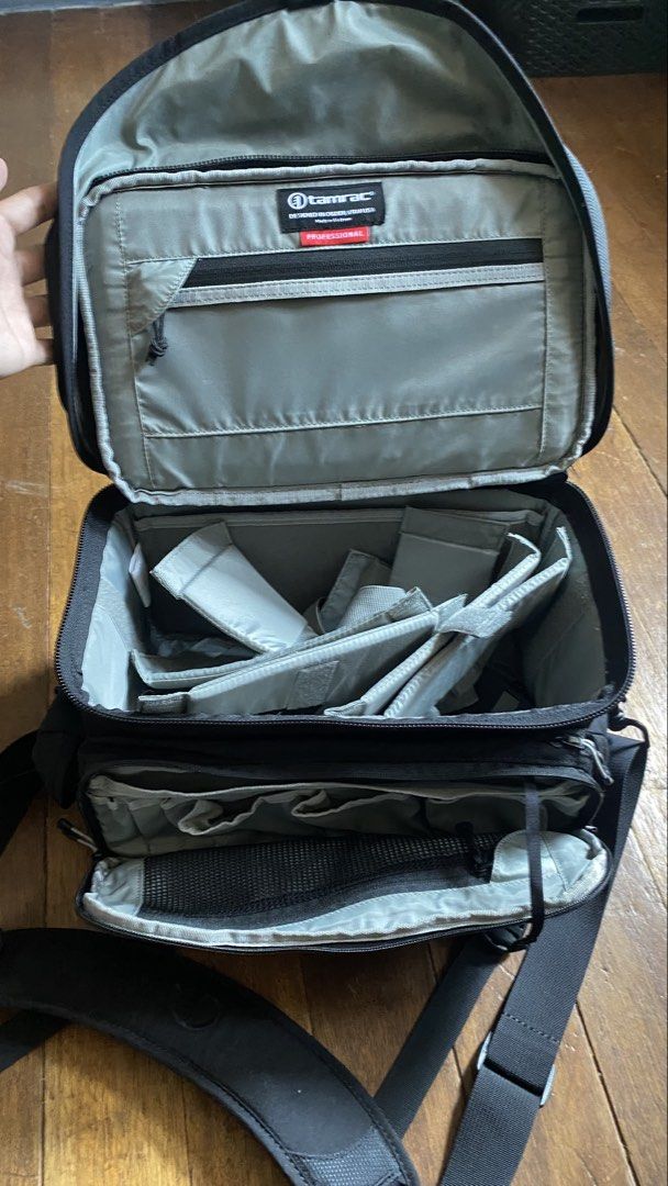 Tamrac Professional Camera Bag (Category: Camera Bags & Carriers) located in Manila. Submitted by rafaelcruz_05 (Listing ID 1450383376, Image 2). Description: - Black Tamrac camera bag - Multiple interior compartments - Adjustable padded dividers for customizable organization - Front pocket for easy access to accessories - Includes a comfortable shoulder strap - Sturdy top handle for alternative carrying - Ideal for photographers needing portabil