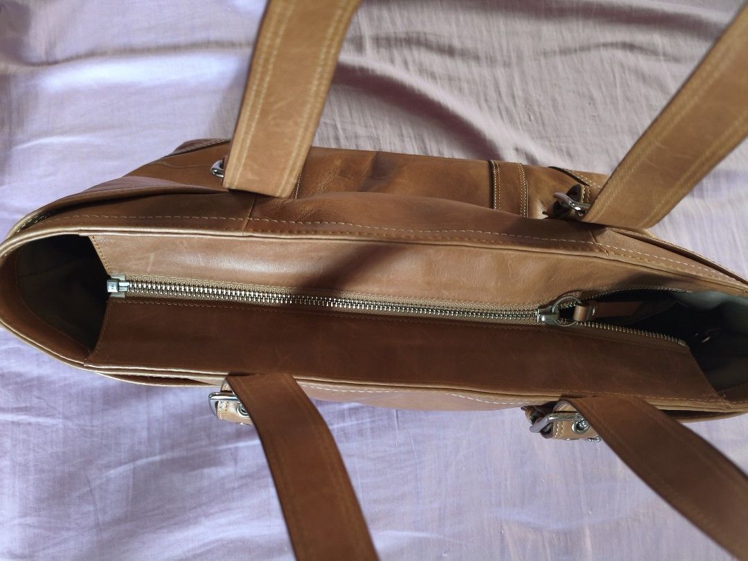 Coach vintage brown leather shoulder bag (Category: Shoulder Bags) located in Pasig City. Submitted by elabart (Listing ID 1450581976, Image 3). Description: - 2000s coach leather bag - dimensions: 46x26 cm - has lots of pocket and space. can fit a laptop. - issue: with light water stain (pls see photos) - i bought this from another seller with the stain already there. I haven't clean it yet since i got it. - aside from the water stain, the bag i