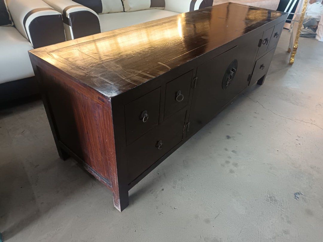 Dark Wood TV Console with Drawers and Cabinet (Category: TV Consoles) located in Kuala Lumpur. Submitted by lazada.kim.huat.furniture (Listing ID 1450677463, Image 2). Description: - Dark wood TV console - Multiple drawers on the sides for storage - Central cabinet with decorative metal clasp - Plenty of storage space inside - Minor scratches on the top surface from use - Ideal for organizing your entertainment area.