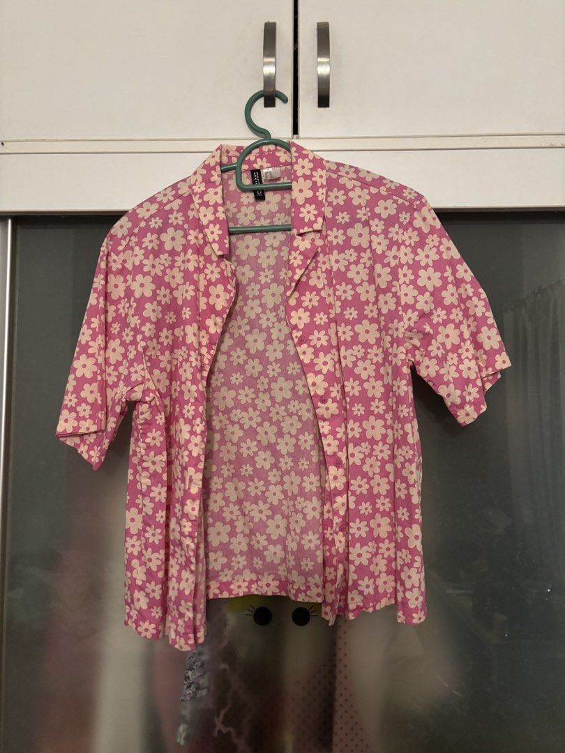 H&M Pink Floral Short Sleeve Button Up Shirt (Category: Other Tops) located in Shah Alam. Submitted by by.mei (Listing ID 1450646008, Image 1). Description: - Pink short sleeve shirt - Adorable all-over white daisy print - Classic button-up style with collar - Relaxed fit for comfort - Versatile for casual outfits or layering - Pairs well with jeans or shorts.