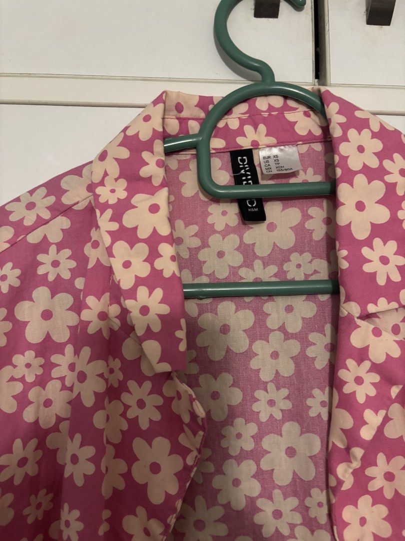 H&M Pink Floral Short Sleeve Button Up Shirt (Category: Other Tops) located in Shah Alam. Submitted by by.mei (Listing ID 1450646008, Image 2). Description: - Pink short sleeve shirt - Adorable all-over white daisy print - Classic button-up style with collar - Relaxed fit for comfort - Versatile for casual outfits or layering - Pairs well with jeans or shorts.