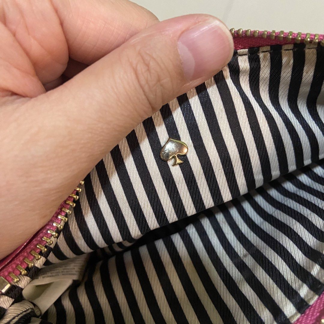 Kate Spade Pink Leather Wristlet Pouch (Category: Purses & Pouches) located in Cavite. Submitted by klosettekleanup (Listing ID 1450706527, Image 2). Description: - Genuine pink pebbled leather Kate Spade wristlet - Iconic silver spade logo on the front - Stylish black and white striped interior lining - Secure zipper closure with a convenient wrist strap - Small stain on the back, clearly shown in photos - Ideal size for carrying your daily esse