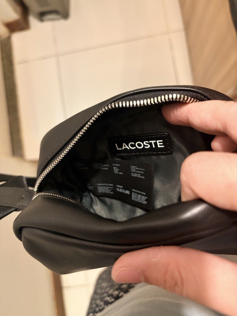 Lacoste Black Leather Crossbody Bag (Category: Cross-body Bags) located in Makati City. Submitted by goodbuyitems (Listing ID 1450654514, Image 2). Description: condition 9/10 decluttering. no issue. seldom used mini size. dimension 10 x 10 x 10 millimetres Black leather crossbody bag from Lacoste. Small and compact, great for essentials. Zipper closure. Adjustable strap. The logo is embossed on the front. Interior tag shows brand details..