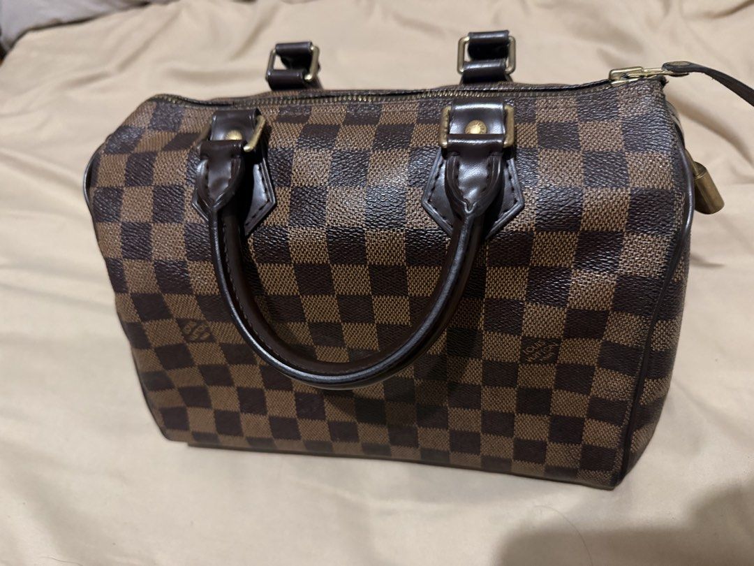 Louis Vuitton Speedy 25 Damier Ebene (Category: Luxury Bags & Wallets) located in Manila. Submitted by milletmend89051 (Listing ID 1450624736, Image 1). Description: - Classic Louis Vuitton Speedy bag - Damier Ebene canvas with iconic checkered pattern - Genuine leather handles and trim - Secure zipper closure with lock - Timeless and versatile for everyday use - Ideal for carrying your essentials.