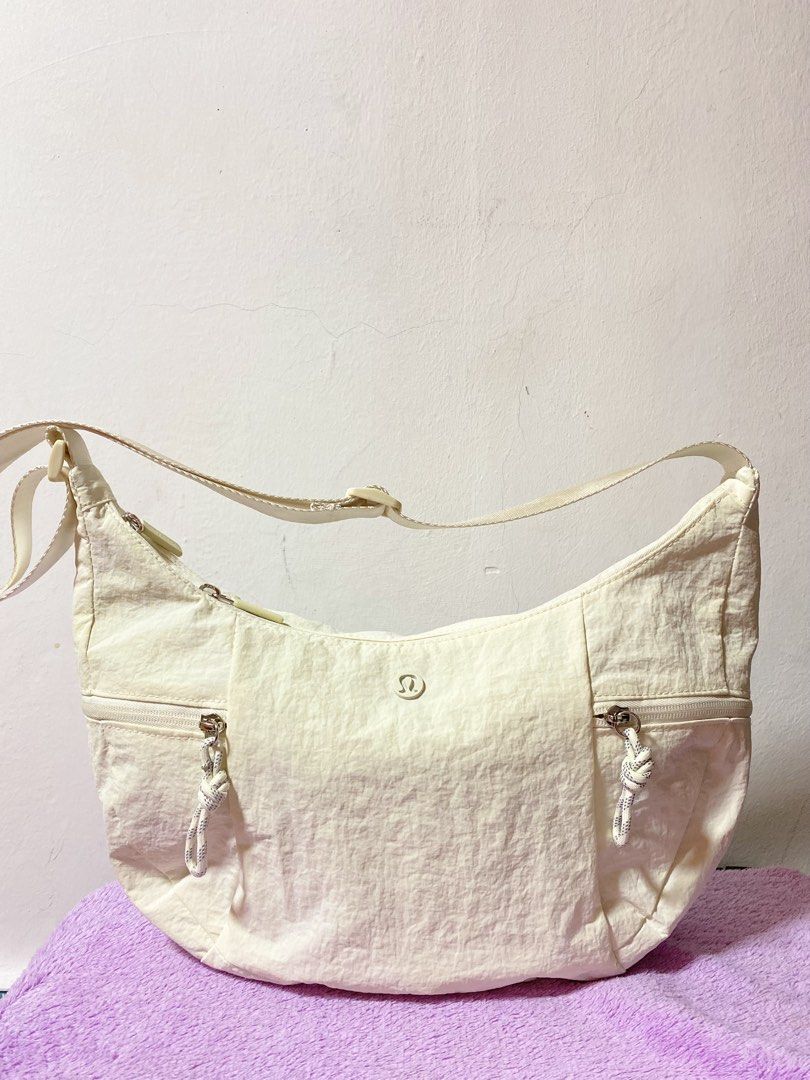 Lululemon Cream Nylon Shoulder Bag (Category: Shoulder Bags) located in Cabuyao City. Submitted by copitos (Listing ID 1450701003, Image 2). Description: - Cream colored Lululemon shoulder bag - Durable nylon material - Multiple zippered pockets on the front - Main compartment with zipper closure - Interior features a zippered pocket and mesh pockets - Adjustable strap for comfortable wear - Ideal for everyday use.