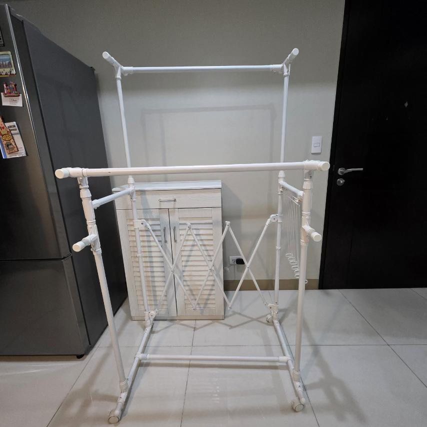 Nitori Extendable Drying Rack with FREE Hanging Shelves (Category: Shelves, Cabinets & Racks) located in Quezon City. Submitted by stylesaverph (Listing ID 1450572321, Image 2). Description: - White metal drying rack - Includes two hanging shelves with a striped pattern - Ideal for laundry or organizing clothes - Equipped with wheels for easy mobility - Sturdy and durable construction - Ready for its new owner- - we will Dismantle when delivered 