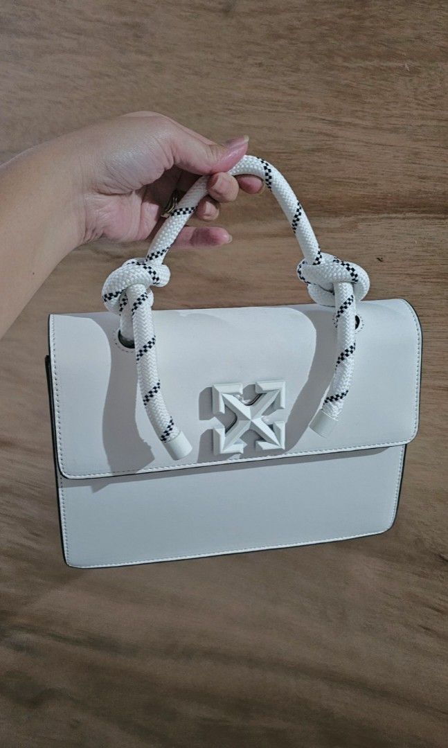 Off-White White Leather Top Handle Bag with Blue Arrows (Category: Luxury Bags & Wallets) located in Makati City. Submitted by mrsdm (Listing ID 1445252330, Image 2). Description: -Comes with strap and box - Iconic white arrow logo on the front - Unique white rope handle - Includes a detachable shoulder strap for versatile carrying - Perfect for adding a vibrant pop of color to any outfit.