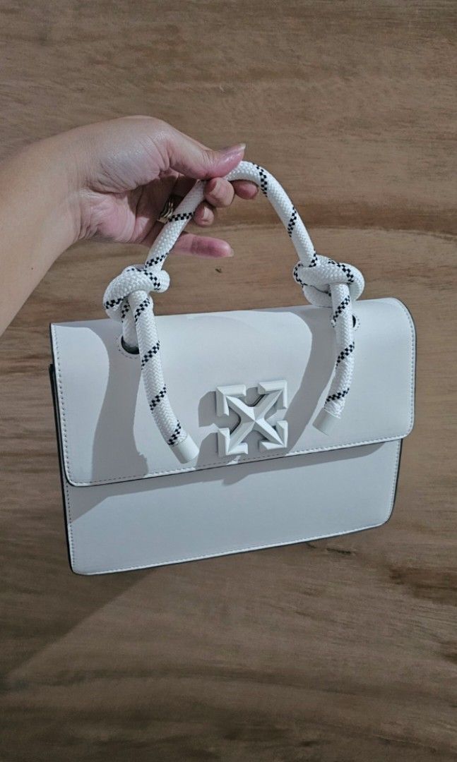 Off-White White Leather Top Handle Bag with Blue Arrows (Category: Luxury Bags & Wallets) located in Makati City. Submitted by mrsdm (Listing ID 1445252330, Image 1). Description: -Comes with strap and box - Iconic white arrow logo on the front - Unique white rope handle - Includes a detachable shoulder strap for versatile carrying - Perfect for adding a vibrant pop of color to any outfit.