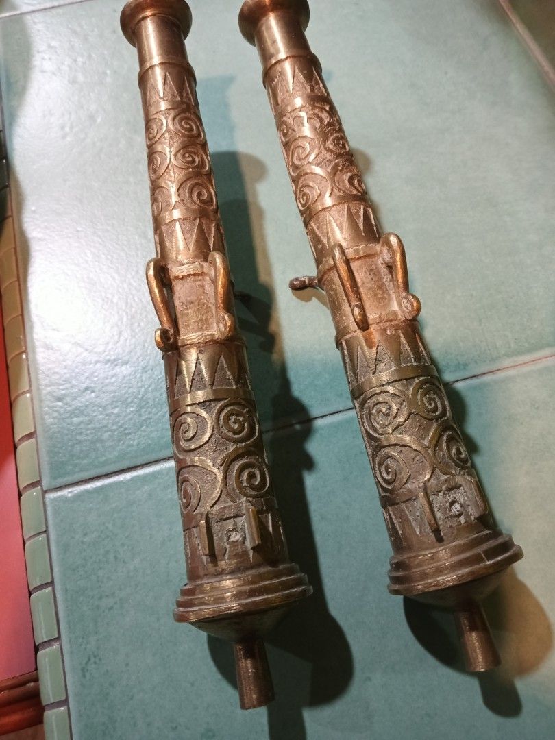 Pair of Antique Brass Decorative Cannons (Category: Vases & Decorative Bowls) located in Kajang. Submitted by d_antique (Listing ID 1450571265, Image 3). Description: - Set of 2 decorative brass cannons - Intricate carvings and vintage aesthetic - Adds a unique touch to any display or decor - Features a small lever detail on each cannon pjg 11 inci.