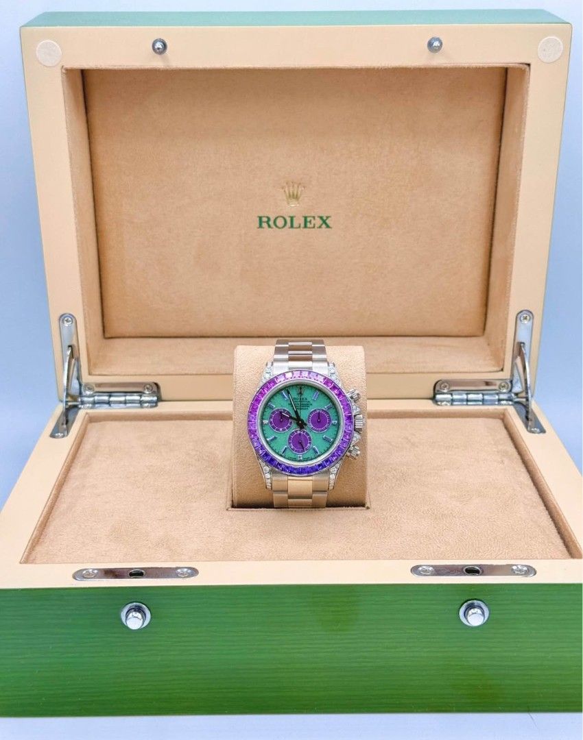 Rolex Daytona Rainbow Gemstone Watch (Category: Luxury Watches) located in Manila. Submitted by supermom888 (Listing ID 1450573175, Image 1). Description: - Rolex Daytona timepiece - Eye-catching green dial - Distinctive purple sub-dials - Bezel adorned with vibrant rainbow gemstones - Includes original Rolex box - A statement of luxury and style.