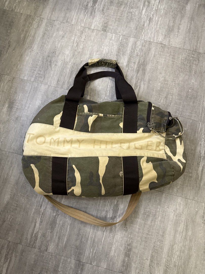 Tommy Hilfiger Camouflage Duffle Bag (Category: Sling Bags) located in Manila. Submitted by lostnfound_ph (Listing ID 1450621978, Image 1). Description: - Cool camo duffle bag from Tommy Hilfiger - Features printed logo across the front - Ideal for weekend trips or gym sessions - Includes top handles and a detachable shoulder strap - Plenty of internal space for essentials - Ready for your next adventure!.