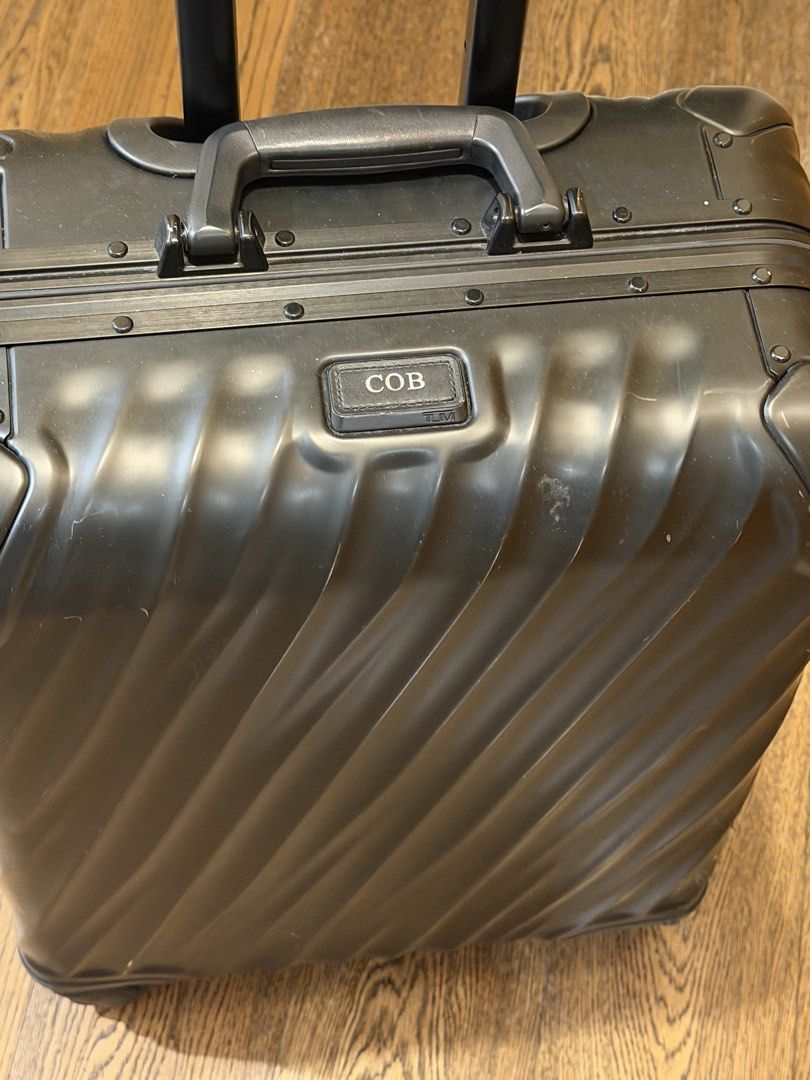 Tumi Black Hard Shell Carry-On Luggage (Category: Luggage) located in Makati City. Submitted by coterba (Listing ID 1450705698, Image 3). Description: - Brand: Tumi - Color: Black - Type: Hard Shell Carry-On - Features: TSA-approved locks, retractable handle, four spinner wheels - Condition: Minor scuffs from normal travel - Personalization: Includes a tag that says 'COB'.