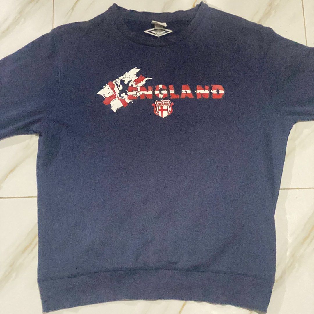 Umbro England Navy Blue Sweatshirt (Category: Coats, Jackets and Outerwear) located in Manila. Submitted by r_vmvnd (Listing ID 1450615501, Image 1). Description: - Navy blue sweatshirt - Features 'England' graphic and St George's Cross - Made in England by Umbro - Perfect for England fans.