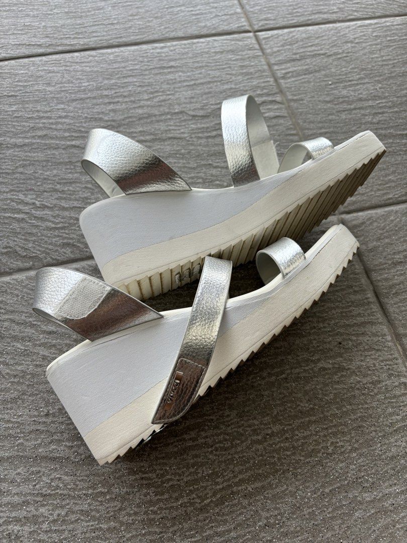 Vincci Silver White Wedge Platform Sandals Heels (Category: Wedges) located in Putrajaya. Submitted by tempetai (Listing ID 1450645466, Image 2). Description: - Brand: Vincci - Style: Wedge Heels Sandals - Color: Metallic Silver straps, White sole with Grey accent - Features: Platform sole, Ankle strap - Size: EURO 40 / UK 7 / US 9 ⚠️ Cat not included. The furry supermodel doesn’t come with the heels. .