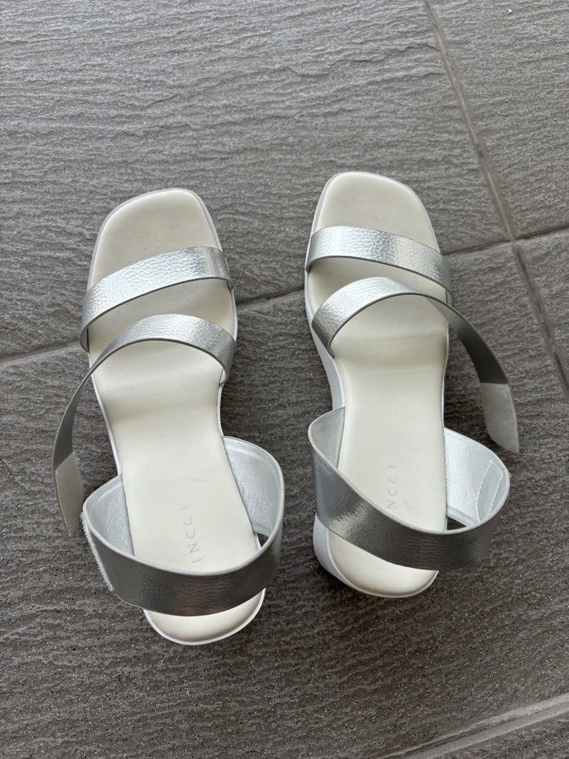 Vincci Silver White Wedge Platform Sandals Heels (Category: Wedges) located in Putrajaya. Submitted by tempetai (Listing ID 1450645466, Image 3). Description: - Brand: Vincci - Style: Wedge Heels Sandals - Color: Metallic Silver straps, White sole with Grey accent - Features: Platform sole, Ankle strap - Size: EURO 40 / UK 7 / US 9 ⚠️ Cat not included. The furry supermodel doesn’t come with the heels. .