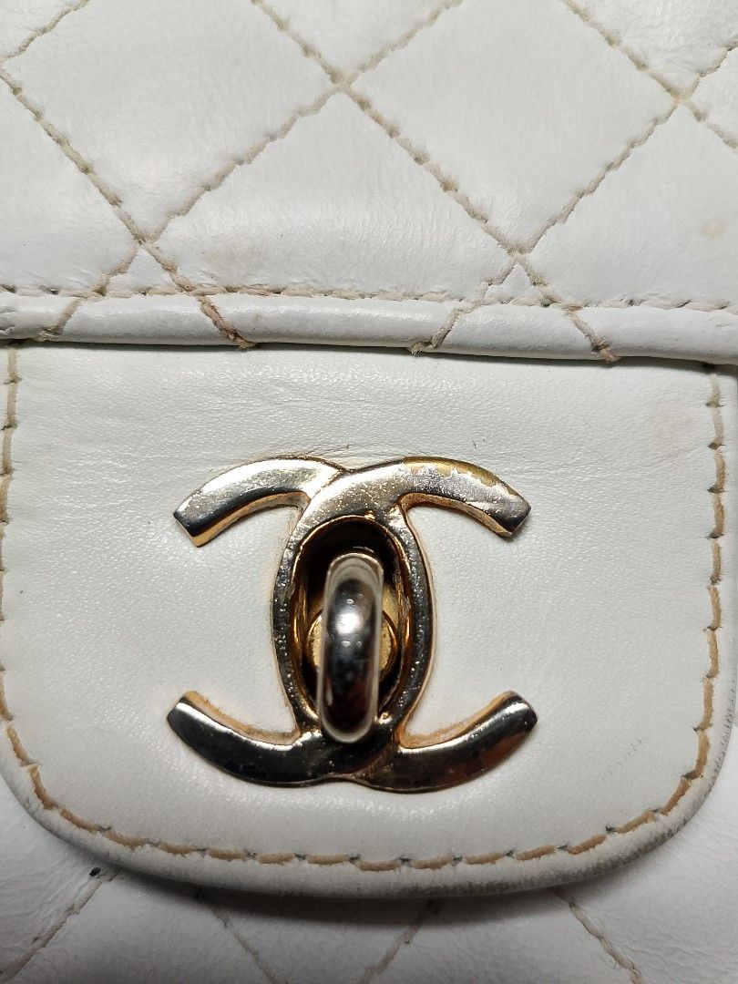 White Quilted Leather Chanel Flap Bag (Category: Luxury Bags & Wallets) located in Manila. Submitted by sheshe.888 (Listing ID 1450709807, Image 3). Description: - Classic white quilted leather flap bag - Features a gold chain strap - Iconic CC turn-lock closure - Interior zippered pocket - Shows some signs of wear on leather and hardware - Still a beautiful and stylish piece - preloved - sign of use.