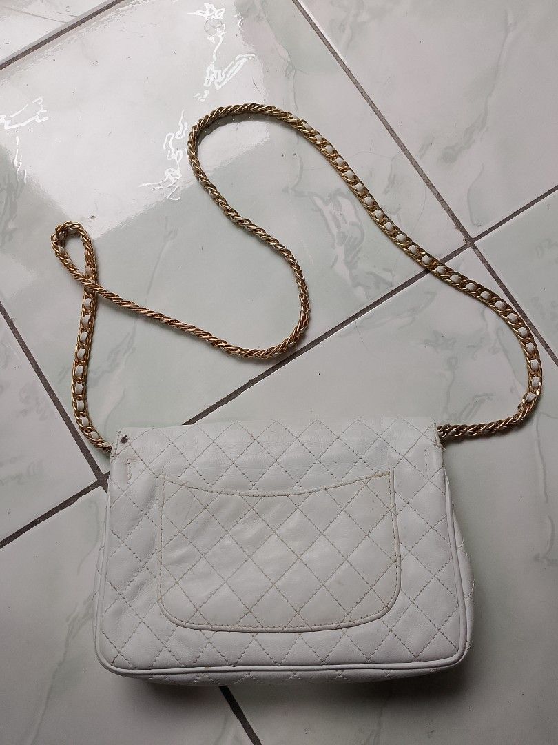 White Quilted Leather Chanel Flap Bag (Category: Luxury Bags & Wallets) located in Manila. Submitted by sheshe.888 (Listing ID 1450709807, Image 2). Description: - Classic white quilted leather flap bag - Features a gold chain strap - Iconic CC turn-lock closure - Interior zippered pocket - Shows some signs of wear on leather and hardware - Still a beautiful and stylish piece - preloved - sign of use.