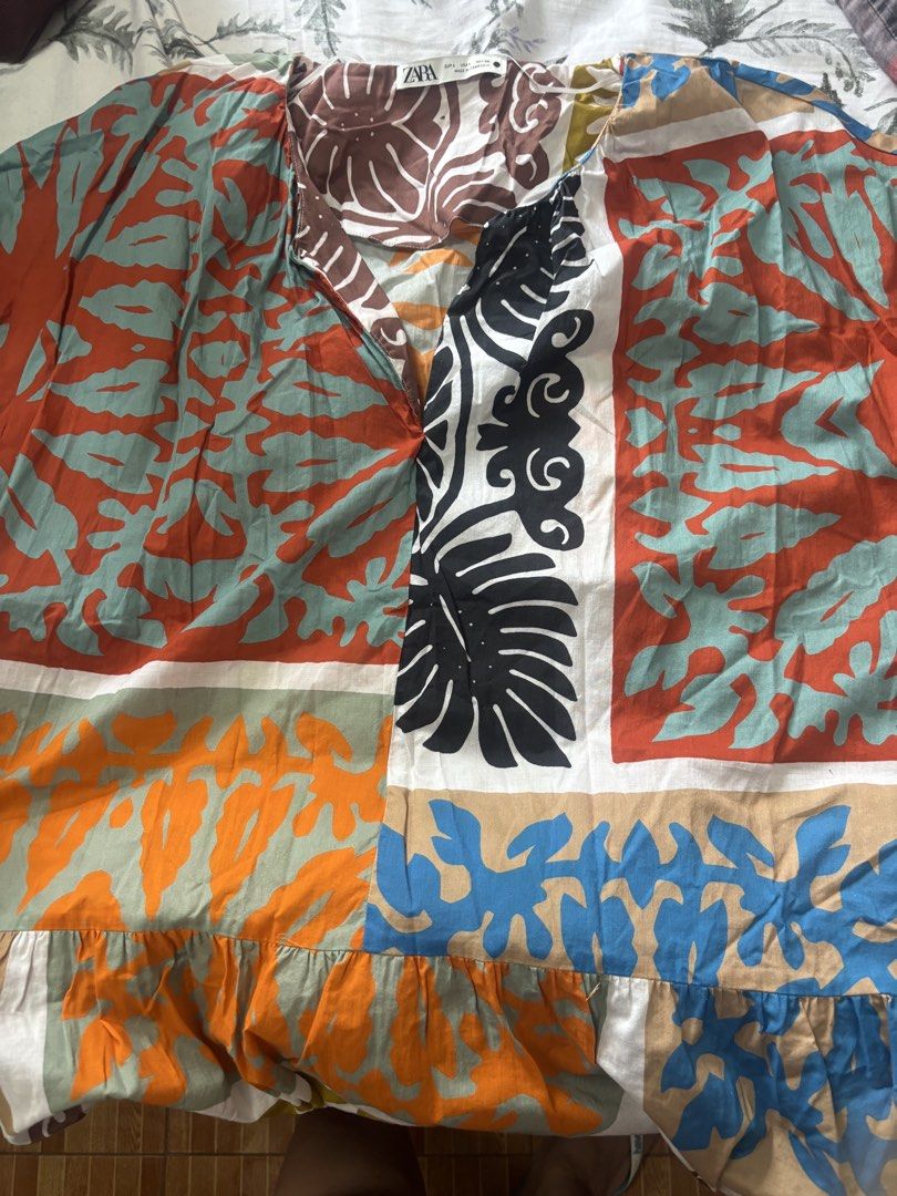 ZARA Patchwork Print longDress Size L (Category: Dresses) located in Malabon City. Submitted by pjarme (Listing ID 1450534230, Image 3). Description: - Zara Long Dress - Size: L but fits up to XXL - Design: Colorful patchwork print with various motifs - V-neck with pockets on both sides - Sleeves: Short sleeves - Skirt: Tiered with ruffled hem - Measurements: Approx. 24 inches across the chest - Occasion: Casual outings, beach vacation Worn only 