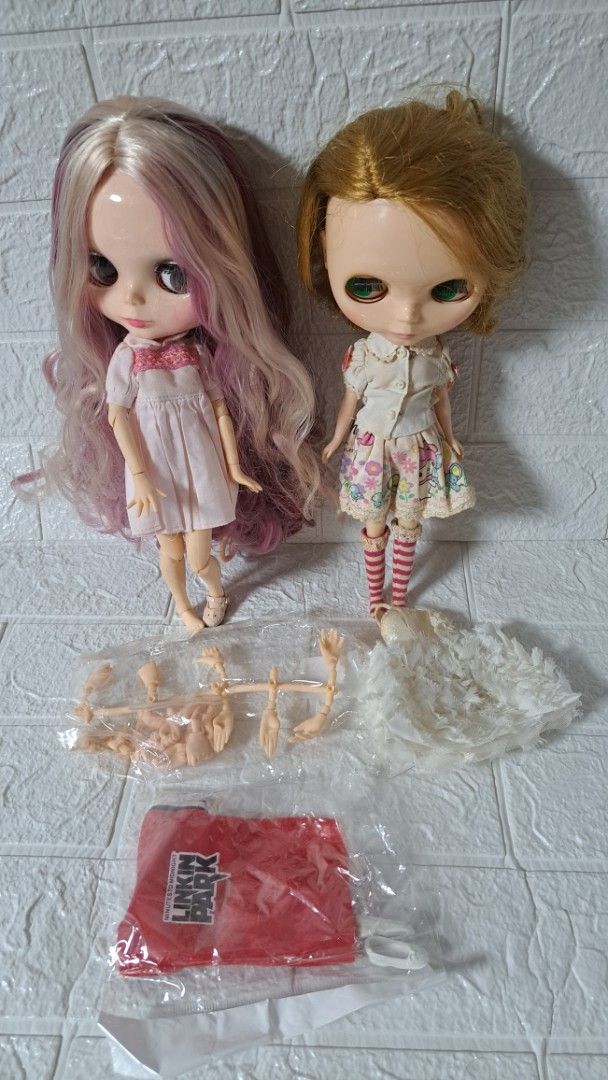 2x Blythe Dolls with Accessories - Hasbro 2006 (Category: Kids Toys) located in Quezon City. Submitted by hersheejubilo (Listing ID 1447232139, Image 2). Description: - Two authentic Hasbro Blythe dolls from 2006. - One doll features blonde hair and a floral dress. - The second doll has long purple and blonde hair and a white dress. - Comes with extra doll parts for customization. - Includes a stylish red bag. - Perfect for Blythe doll collectors