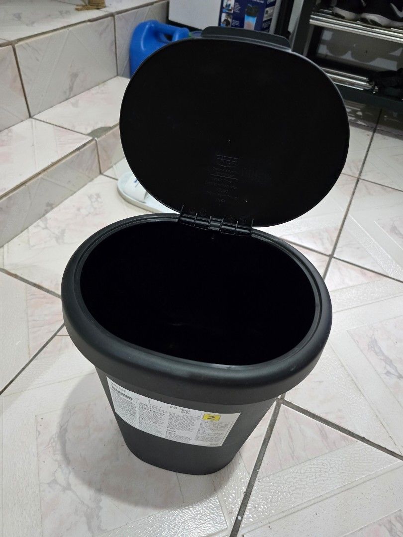 Black Round Trash Can with Hinged Lid (Category: Storage Boxes & Baskets) located in Makati City. Submitted by shopaholicsgallery (Listing ID 1447124162, Image 2). Description: - Sleek black round trash can - Convenient hinged lid for easy access - Versatile design, suitable for any room - Durable and sturdy plastic construction - Features labels on the side - Dimensions: H35cm x W25cm × D20cm - Brand: IKEA.