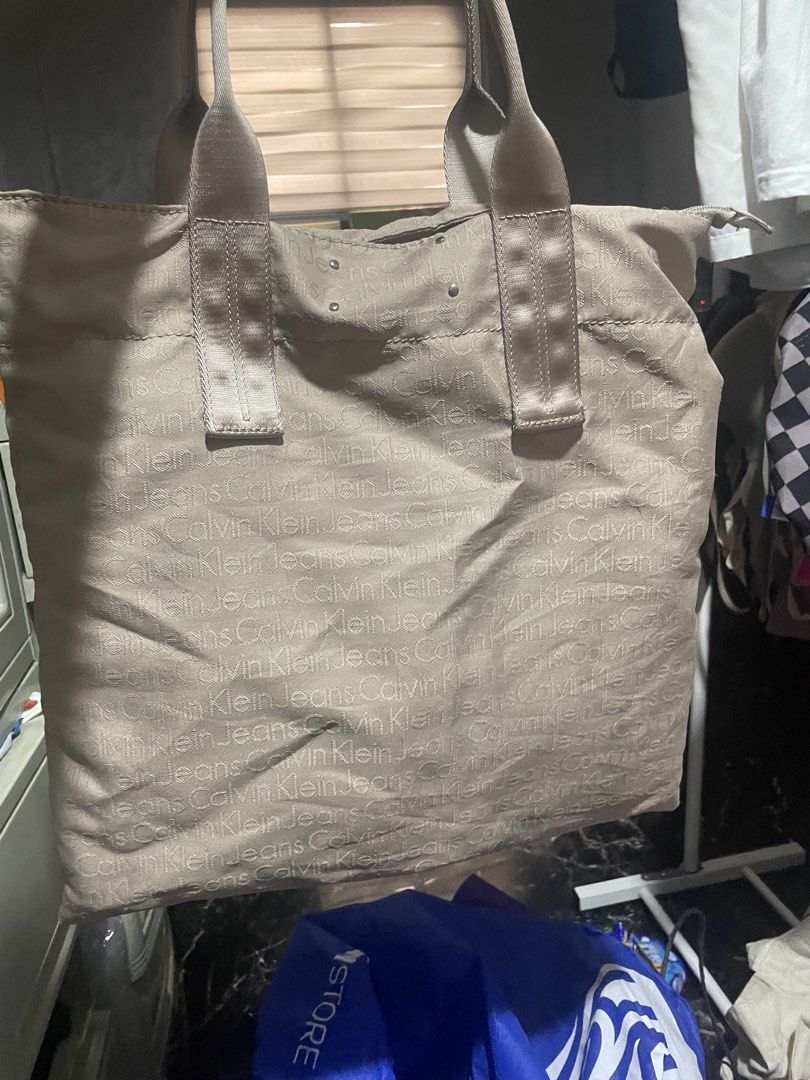Calvin Klein Jeans Monogram Tote Bag (Category: Luxury Bags & Wallets) located in Marikina City. Submitted by diazjeniel90559 (Listing ID 1447221388, Image 2). Description: May stain see the pic not sure qng matanggal hiniram pamangkin q s scholl gnyan n pagbalik - Authentic Calvin Klein Jeans tote bag - Features an all-over CKJ monogram print - Elegant neutral beige color .