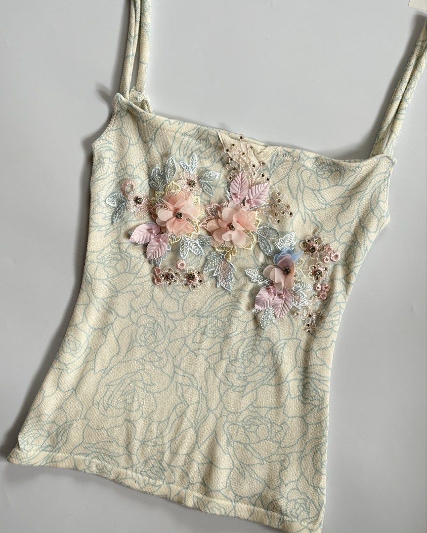 Cream Floral Embellished Cami Top (Category: Sleeveless) located in Manila. Submitted by secondtimearound__ (Listing ID 1447223582, Image 2). Description: - Cream cami top with a delicate floral pattern. - Features charming 3D floral embellishments on the front. - Adjustable spaghetti straps for a perfect fit. - Made from soft and stretchy material for comfort. - Versatile piece: great for layering or wearing solo..