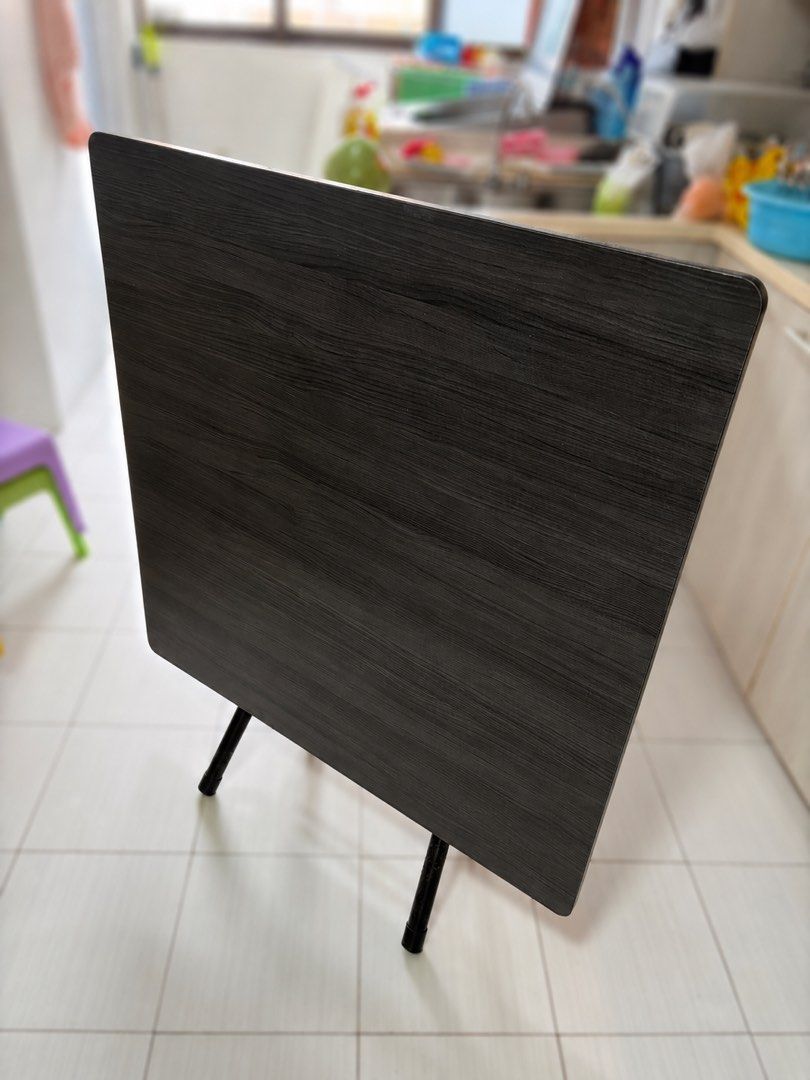 Foldable table (Category: Tables & Sets) located in Singapore. Submitted by vincent_shoshin (Listing ID 1447120277, Image 1). Description: - 90 * 90 * 73cm - Dark wood folding table - Wood grain finish top - Black metal legs fold for easy storage - Ideal for extra dining space or work - Sturdy and practical.