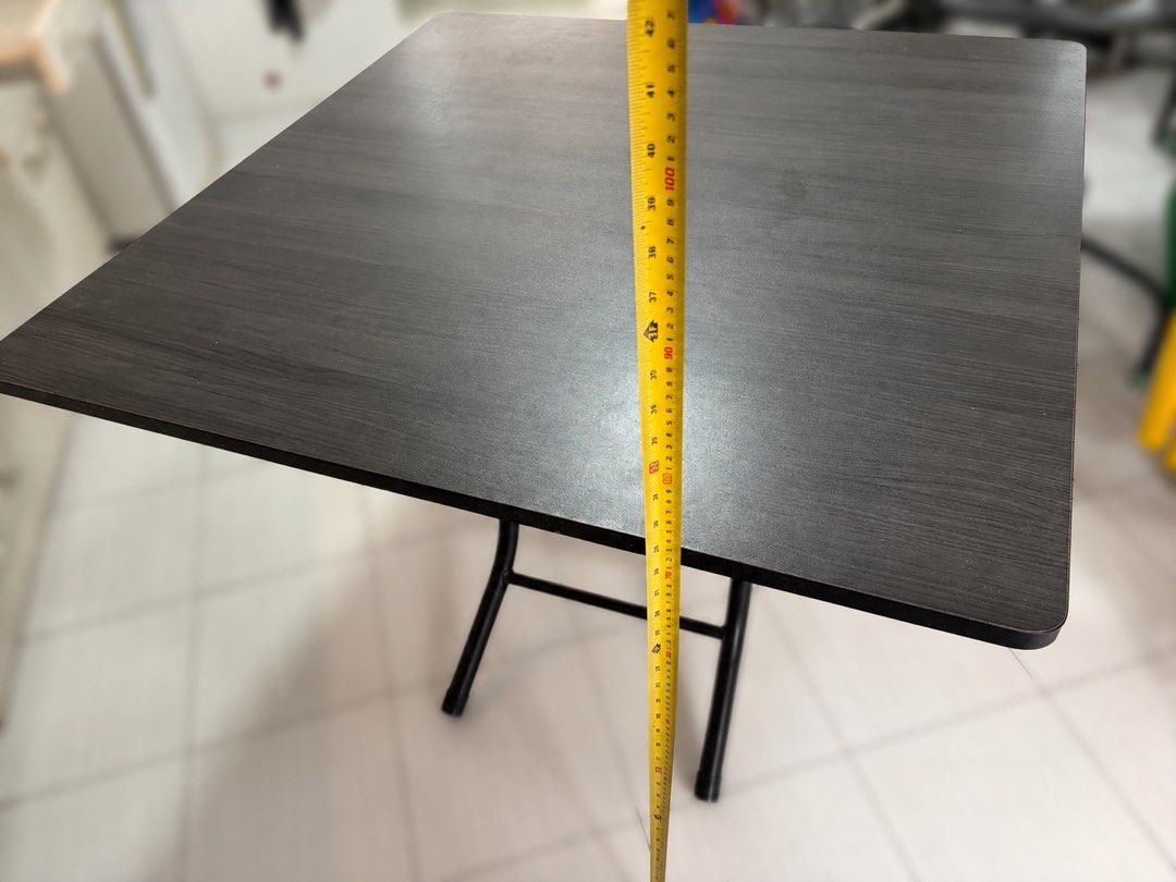 Foldable table (Category: Tables & Sets) located in Singapore. Submitted by vincent_shoshin (Listing ID 1447120277, Image 3). Description: - 90 * 90 * 73cm - Dark wood folding table - Wood grain finish top - Black metal legs fold for easy storage - Ideal for extra dining space or work - Sturdy and practical.