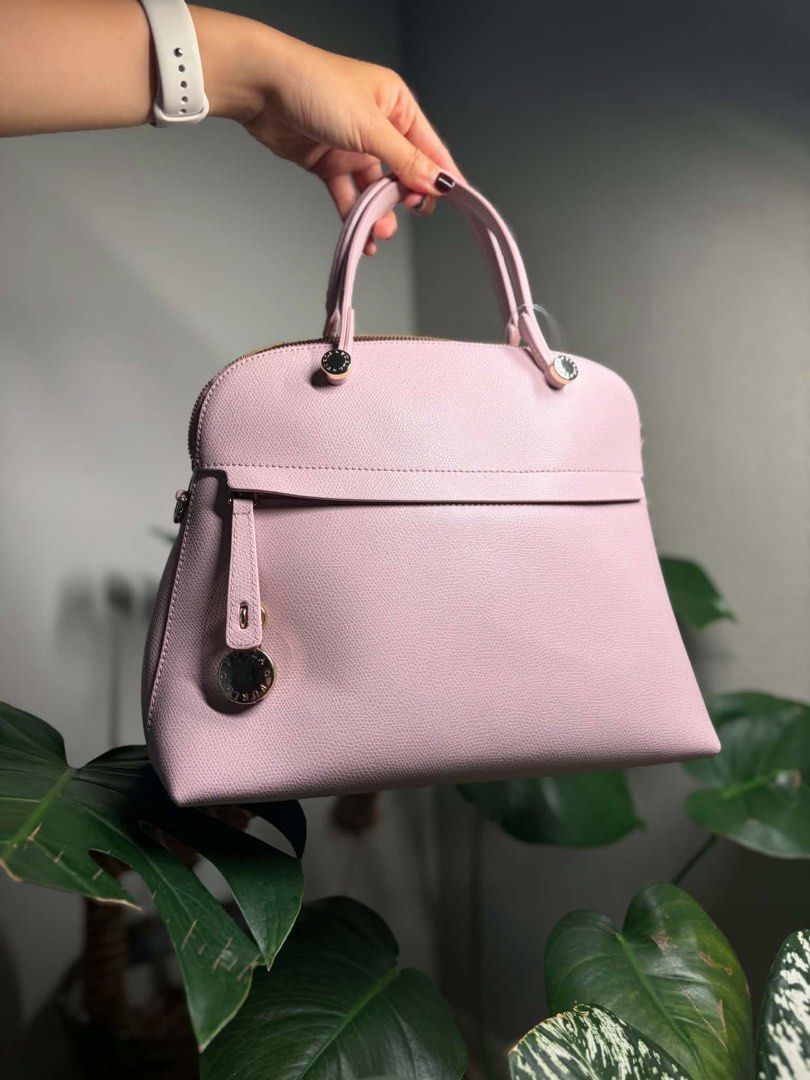 Furla Piper M Dome Bag (Light Pink) (Category: Luxury Bags & Wallets) located in Bulacan. Submitted by lenggayy (Listing ID 1447223883, Image 2). Description: - Adorable pink Furla dome satchel bag - Features a comfortable top handle - Crafted from beautiful pebbled leather - Includes a convenient front flap pocket with a charming detail - Secure zipper closure for the main compartment - Versatile for everyday errands or elegant occasions.