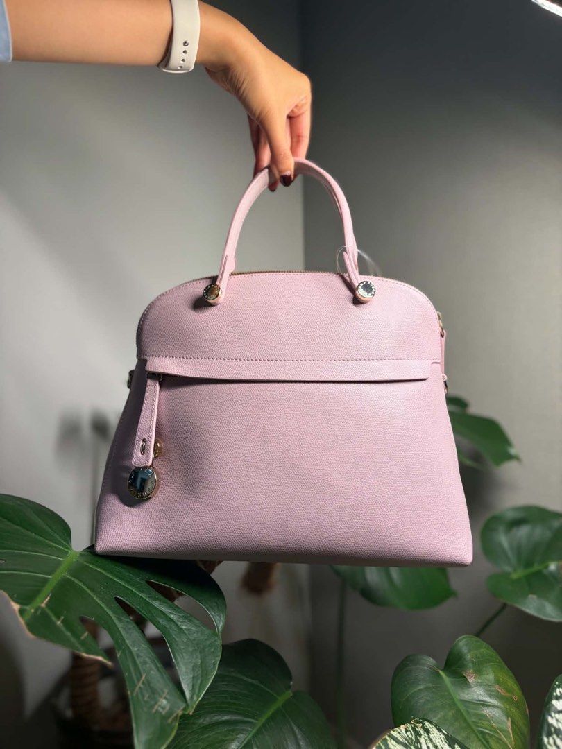 Furla Piper M Dome Bag (Light Pink) (Category: Luxury Bags & Wallets) located in Bulacan. Submitted by lenggayy (Listing ID 1447223883, Image 1). Description: - Adorable pink Furla dome satchel bag - Features a comfortable top handle - Crafted from beautiful pebbled leather - Includes a convenient front flap pocket with a charming detail - Secure zipper closure for the main compartment - Versatile for everyday errands or elegant occasions.
