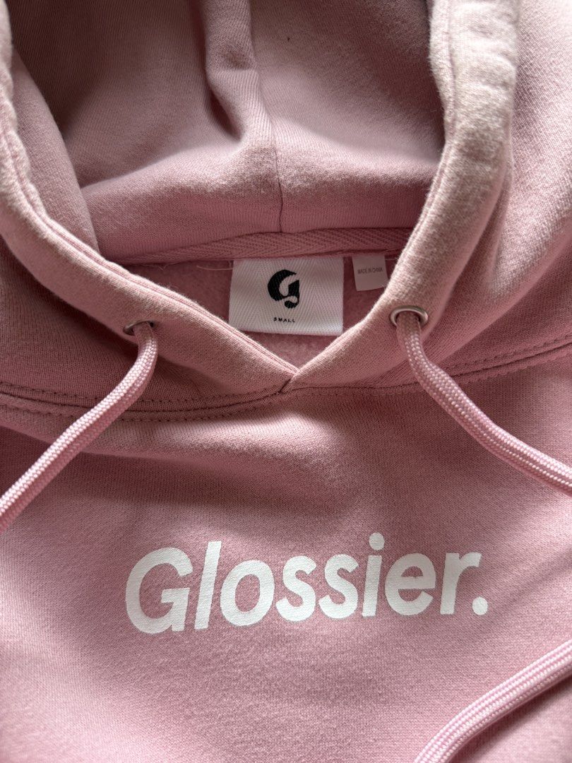 Glossier Pink Hoodie Size Small (Category: Coats, Jackets and Outerwear) located in Marikina City. Submitted by samndbx (Listing ID 1447122161, Image 1). Description: - Pink Glossier hoodie - Size: Small (W: 52cm L: 68cm) - Glossier logo on the front - Smiley face with wave emoji graphic on the back - Kangaroo pocket - Drawstring hood - Retails for ₱4,500.