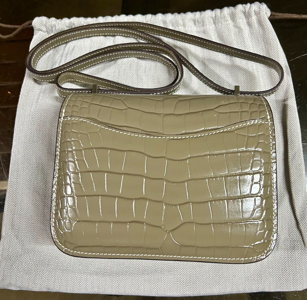 Hermes Constance Bag (Category: Luxury Bags & Wallets) located in Caloocan City. Submitted by hermes_evangelista (Listing ID 1447222694, Image 2). Description: A classic Hermes bag that can be as hard to find as the Birkin or Kelly bag. This pre-loved Hermes Constance in Gris Tourterelle, made of Crocodile Niloticus leather (with the symbol used is a double dot (··) next to the Hermès logo) exudes luxury. This chameleon-like color transforms from