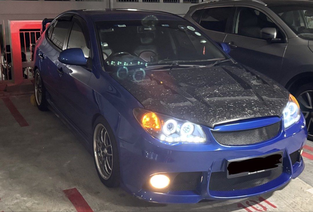 Hyundai Avante Hyundai Avante 1.6 (A) HD Auto (Category: Used Cars) located in Singapore. Submitted by karousellers (Listing ID 1447280379, Image 3). Description: !!Direct Owner!! Blue Hyundai Avante HD sedan. Modified with a carbon fiber hood and sporty body kit. Custom headlights and taillights. Comes with a rear spoiler and aftermarket rims. Ready for a new owner. Excellent Sporty Drive. Efficient fuel consumption! Driver seat woofer Loud Spea