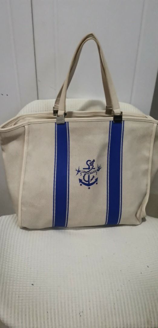 Longchamp Canvas Tote Bag with Anchor Design (Category: Tote Bags) located in Caloocan City. Submitted by ayacuerdo (Listing ID 1447138124, Image 1). Description: - Cream canvas tote bag - Blue stripe pattern - Navy anchor graphic in the center - Top zipper closure for security - Sturdy handles for comfortable carrying - Spacious interior, ideal for beach trips or everyday use.