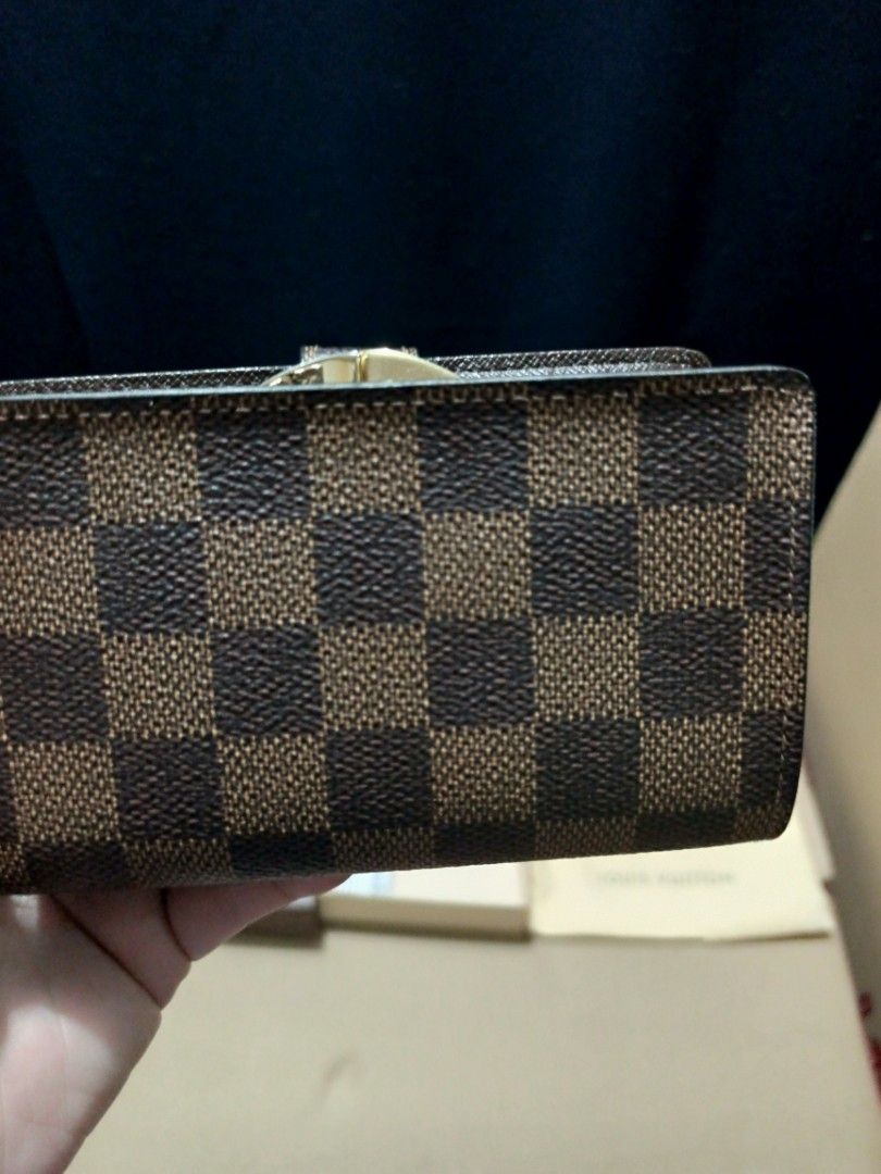 Louis Vuitton Damier Ebene Small Wallet (Category: Luxury Bags & Wallets) located in Manila. Submitted by tindahan.ni.nanay (Listing ID 1447170463, Image 3). Description: Louis Vuitton Damier Ebene French Kiss Lock Wallet It features the iconic brown checkerboard coated canvas, gold-tone hardware, a secure kiss-lock coin pocket, and a snap button opening that reveals cross-grain leather, card slots, and bill compartments With dust bag and box .