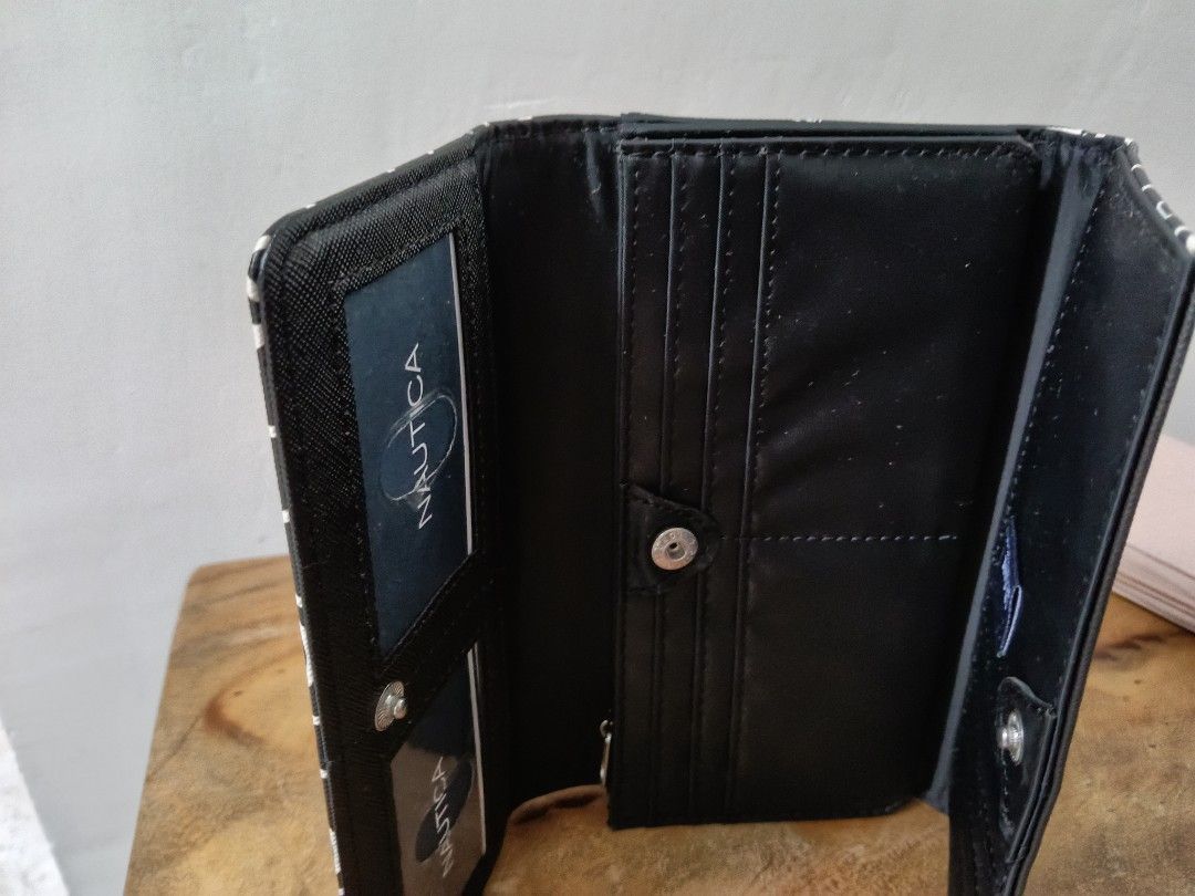 Nautica Black White Logo Print Wallet (Category: Wallets & Card holders) located in Paranaque City. Submitted by 27rcd (Listing ID 1447207557, Image 3). Description: Nautica wallet with all-over logo print. Black with white lettering. Has a zip pocket on the side. Interior has card slots and a button closure. Comes with tags attached. Great for everyday use. 8"W x 4.5" H.