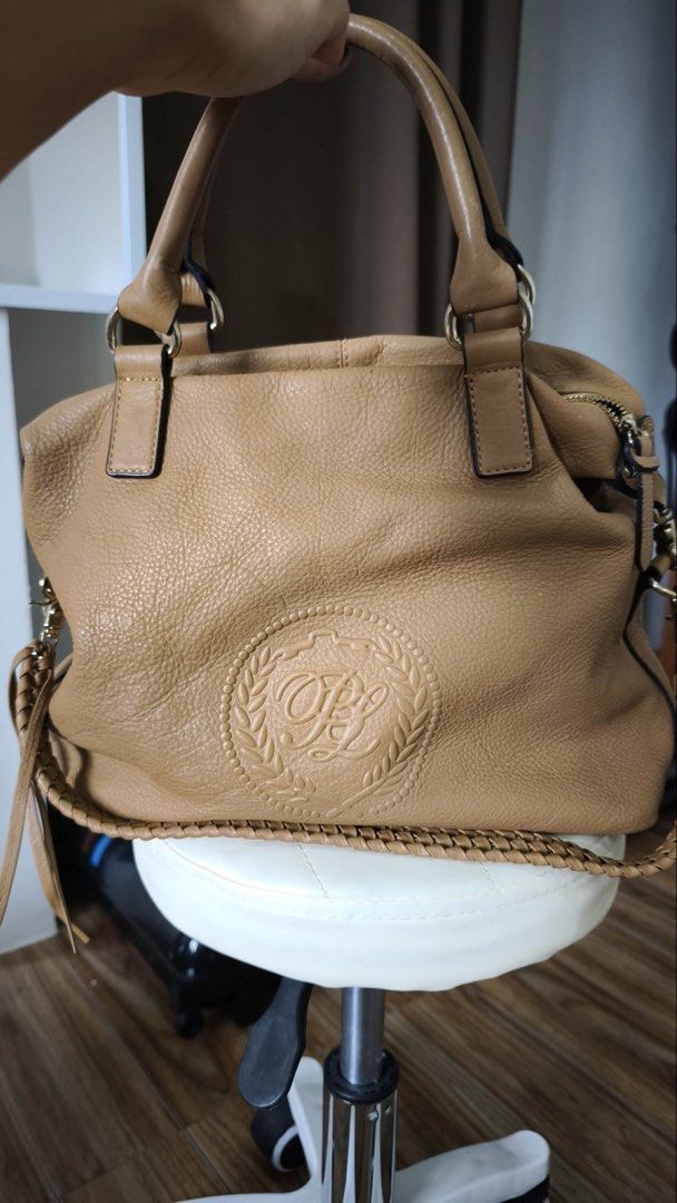 PINN BAKER Leather Handbag Tan (Category: Luxury Bags & Wallets) located in Antipolo. Submitted by waco1313 (Listing ID 1447146570, Image 1). Description: - Tan pebbled leather handbag - Braided side detail - Tassel zipper pulls - Interior with multiple compartments - Patterned lining - Gold hardware - Detachable shoulder strap included.