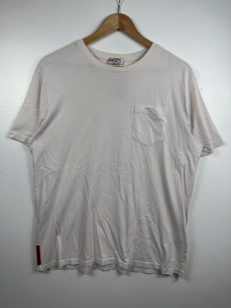 Prada White Pocket T-Shirt XL (Category: Tshirts & Polo Shirts ) located in Manila. Submitted by collect__ph (Listing ID 1447131987, Image 1). Description: - Authentic Prada Pocket Tee - Size: 26.5” L x 22” W - Signature red Prada tab on the side - Material: 100% Cotton - Care: Wash cold, inside out, separately. Do not soak/wring. Iron on dry clean setting..
