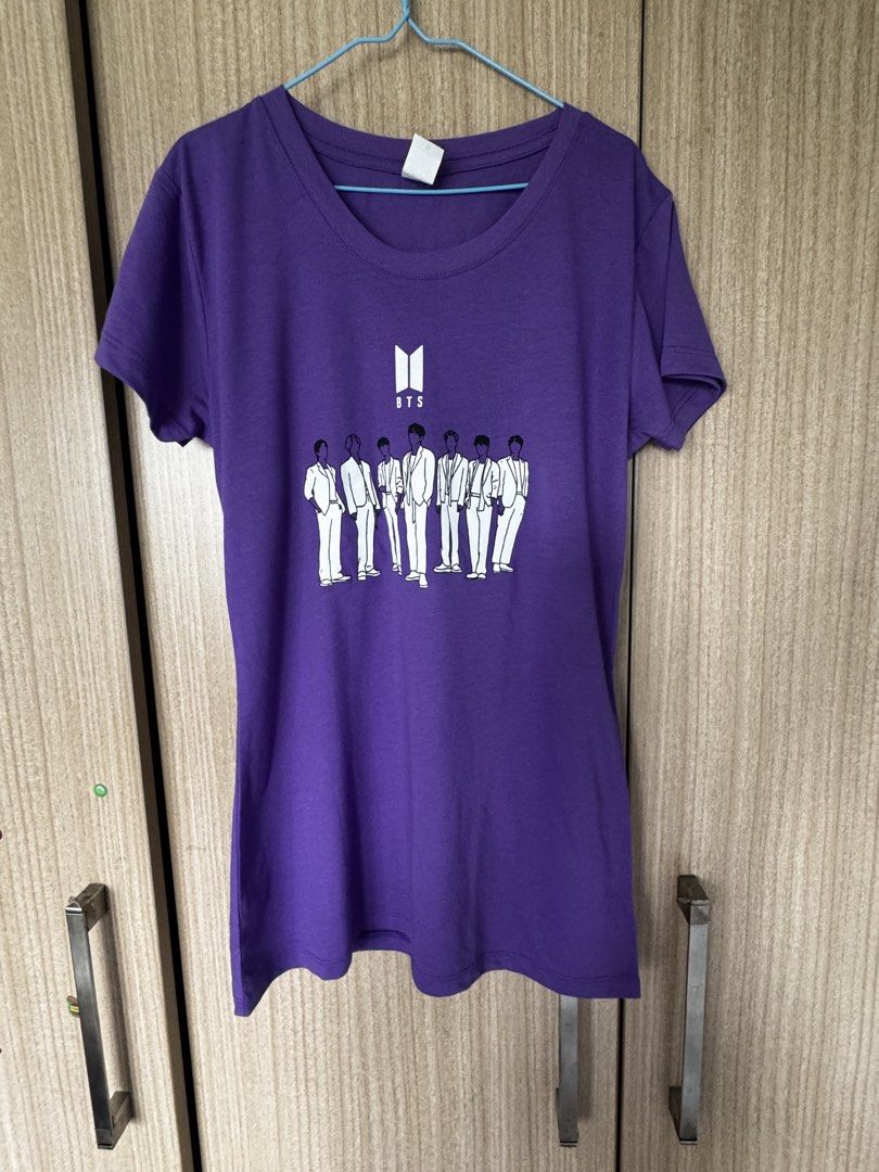 Purple BTS T-shirt with Group Graphic (Category: Shirts) located in Taguig. Submitted by misstangerine (Listing ID 1447273287, Image 1). Description: - Purple t-shirt featuring a graphic of BTS members and the BTS logo. - Made from comfortable cotton material. - Ideal for casual wear or attending concerts. - A must-have for any ARMY! - armpit to armpit ~ 14 inches length ~26 inches - No tag never worn bought in the USA. .