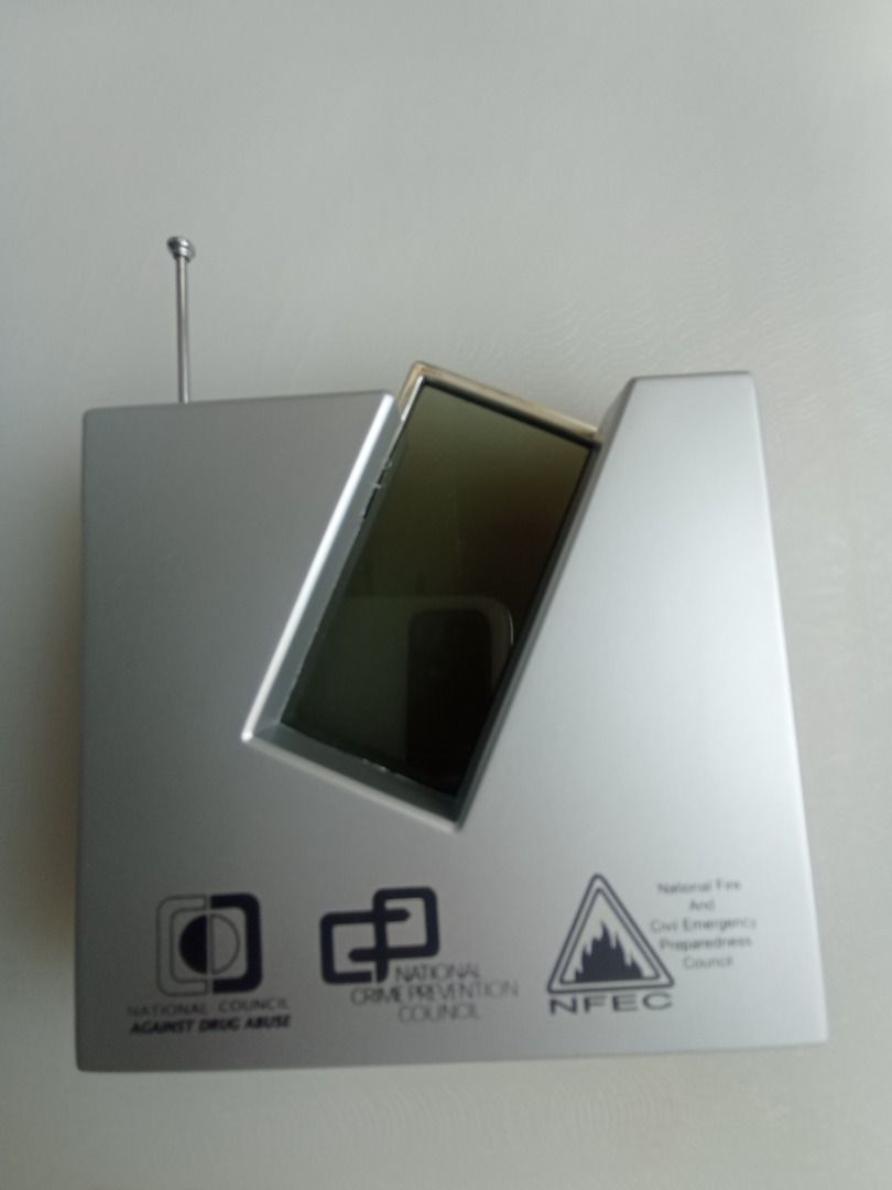 Radio Clock (Category: Clocks) located in Singapore. Submitted by tpdavid (Listing ID 1447215850, Image 2). Description: - Silver radio clock - Displays time and date - Buttons: mode, set, reset, scan - Antenna is extended - Ideal for desk or bedside table.