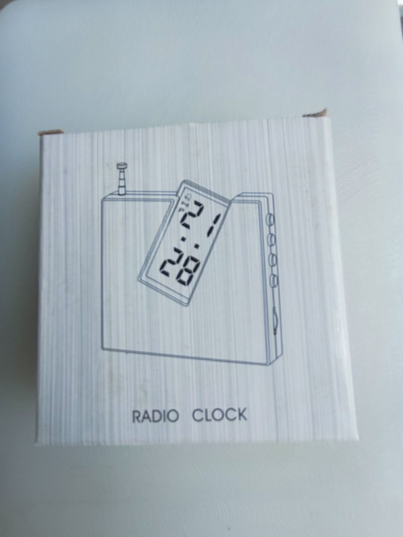 Radio Clock (Category: Clocks) located in Singapore. Submitted by tpdavid (Listing ID 1447215850, Image 1). Description: - Silver radio clock - Displays time and date - Buttons: mode, set, reset, scan - Antenna is extended - Ideal for desk or bedside table.
