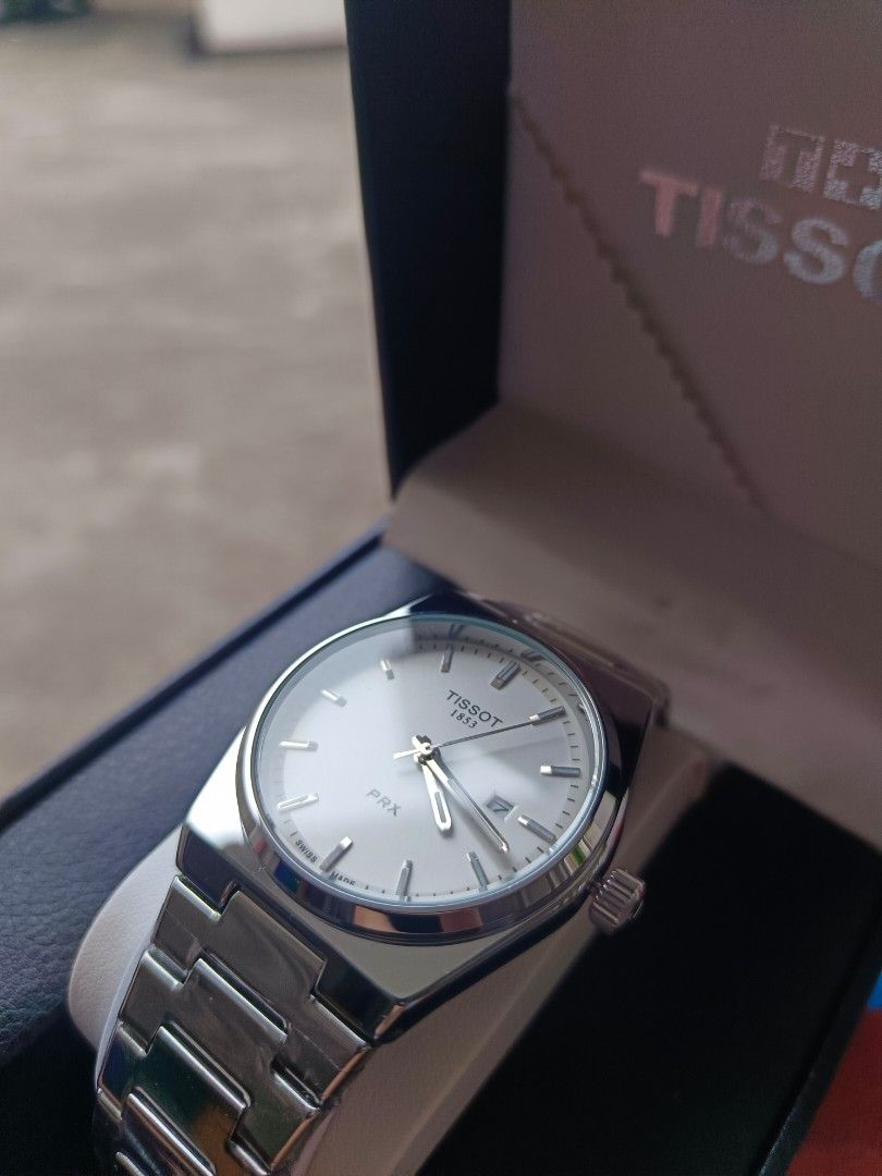 Tissot PRX Watch 1:1 (Category: Luxury Watches) located in Caloocan City. Submitted by seiji09723 (Listing ID 1446086255, Image 2). Description: - Tissot PRX Watch - Classic silver stainless steel design - White dial with date window - Comes with original box and Tissot paper bag - Versatile for everyday wear or special occasions - Feel free to ask questions!.