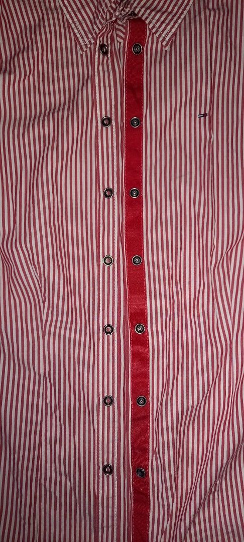 Tommy Hilfiger Denim Red Striped Short Sleeve Shirt (Category: Shirts) located in Cagayan de Oro. Submitted by edwardryan01984 (Listing ID 1447129708, Image 3). Description: - Tommy Hilfiger Denim Shirt - Length 27 inches - Width 17 inches - Classic red and white stripes - Short sleeves - Button-up front - Small logo on chest pocket - Unique collar detail - Ideal for casual wear.