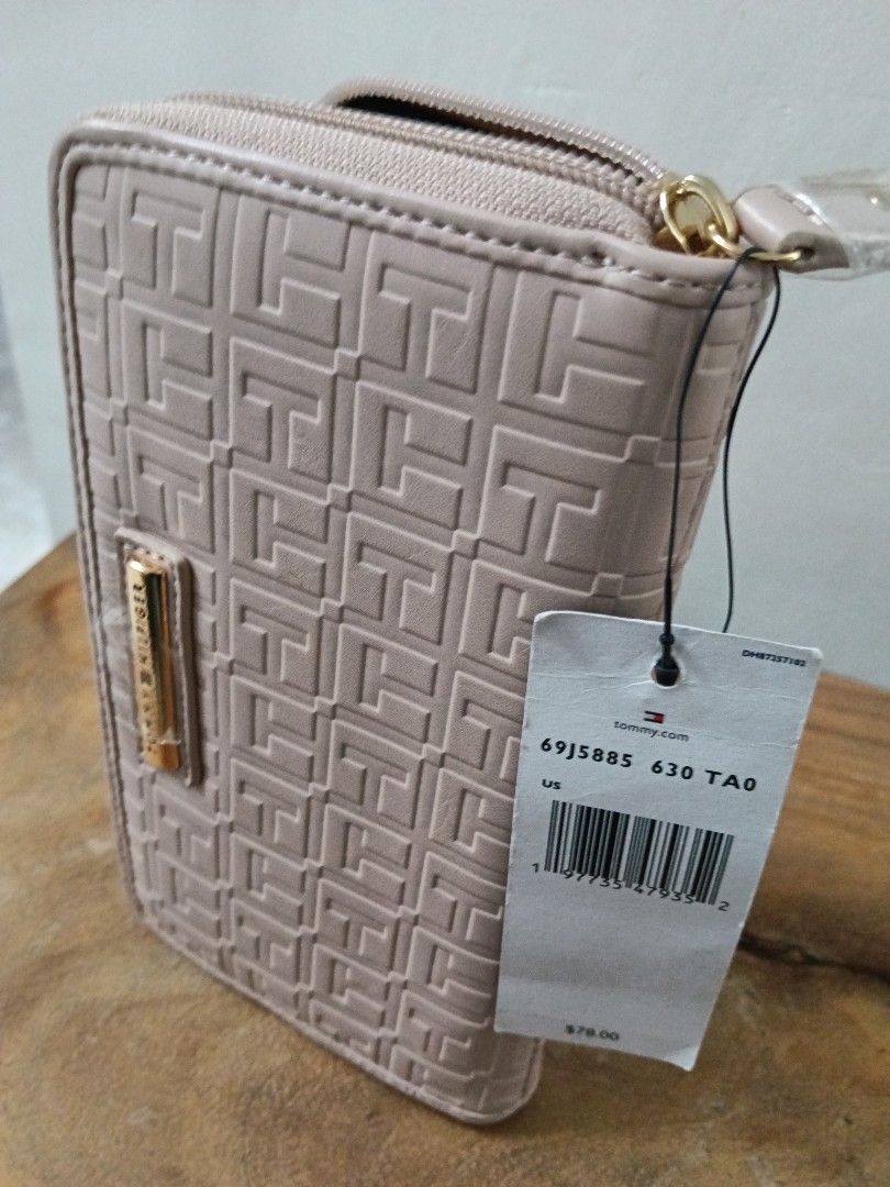 Tommy Hilfiger Embossed Logo Zip Around Wallet (Category: Wallets & Card holders) located in Paranaque City. Submitted by 27rcd (Listing ID 1447207851, Image 2). Description: Tommy Hilfiger wallet. Embossed with the TH monogram all over. Zip around closure. Gold tone hardware. Comes with original tags attached. Nice neutral color, great for everyday use. 8" W x 4.5" H.