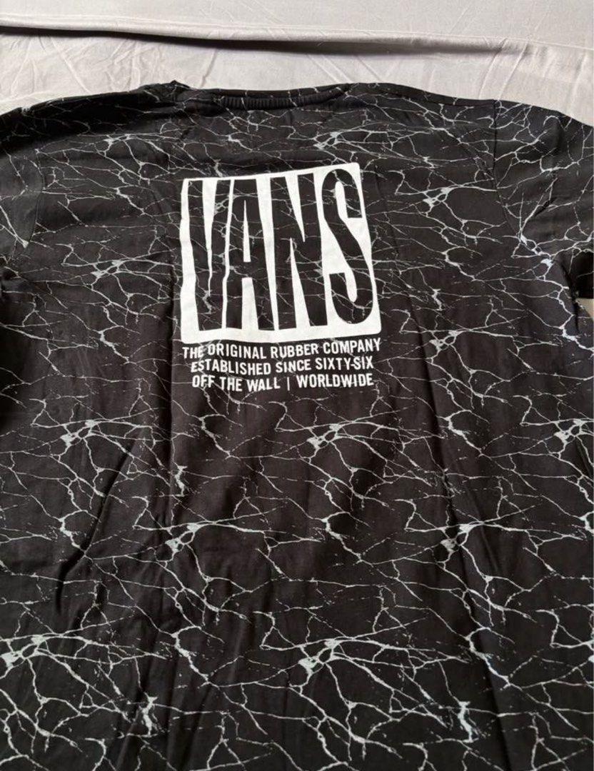 Vans T-Shirt Large Black Marble Print (Category: Tshirts & Polo Shirts ) located in Silang. Submitted by declutterswuni (Listing ID 1447210780, Image 2). Description: - Black Vans T-shirt - Size: Large - Unique marble print design - Features Vans logo - Text on back: 'The Original Rubber Company' - Ideal for everyday casual wear.