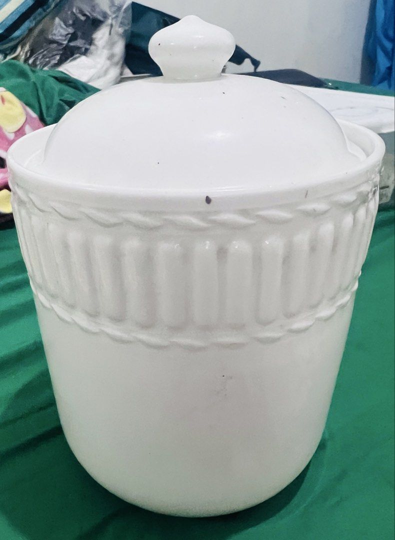 White Ceramic Storage Jar with Lid (Category: Food Organization & Storage) located in Pasig City. Submitted by mavrugbys_123 (Listing ID 1447204299, Image 1). Description: - Elegant white ceramic jar with a matching lid. - Features decorative rope and ribbed pattern around the top. - Stands approximately 8 inches tall. - Ideal for storing kitchen essentials or as a stylish decorative accent..