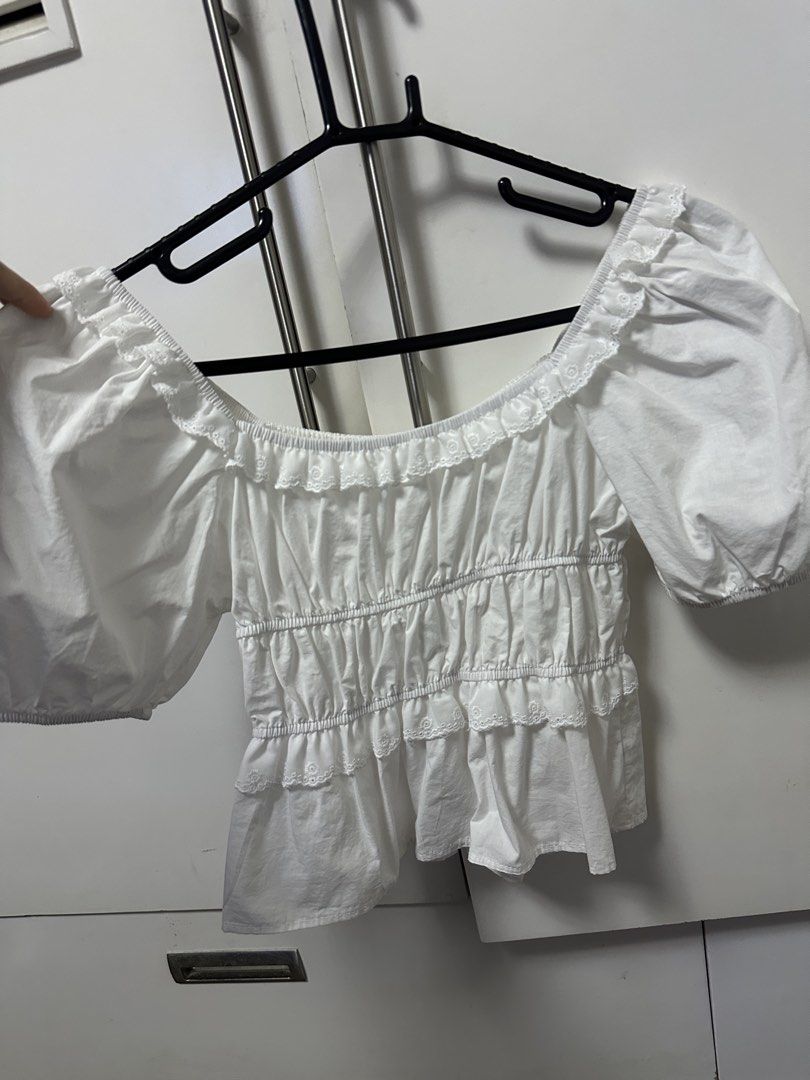 White Puff Sleeve Off-Shoulder Ruffle Crop Top (Category: Blouses) located in Angeles City. Submitted by decluttertime.vela (Listing ID 1447285589, Image 1). Description: - Cute white puff sleeve top - Off-shoulder design with ruffle neckline - Smocked waist for a flattering fit - Tiered ruffle hem - Short sleeves with elastic cuffs - Perfect for casual or dressy occasions - Easily pairs with skirts or shorts.