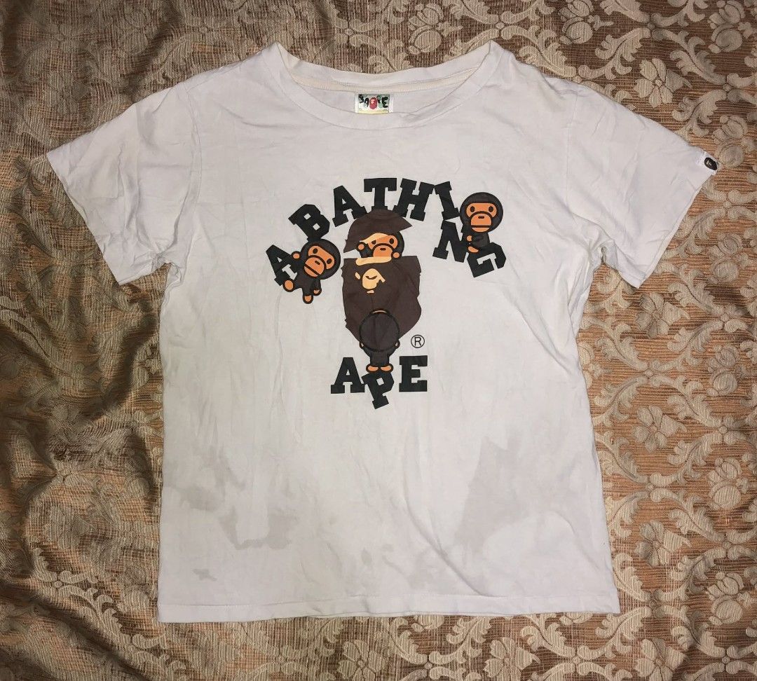 BAPE AAPE By A Bathing Ape T-Shirt (Category: Tshirts & Polo Shirts ) located in Manila. Submitted by rai_0413 (Listing ID 1450888955, Image 1). Description: - Brand: BAPE - Color: White - Size: S - Material: 100% Cotton - Style: Casual wear - Condition: Good - Features: Classic ape graphic with intricate details 19x23 need wash oil stain sign of usage neck 8.5 CR.